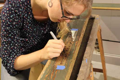 Adeline Myers works on restoration of the frame (photo courtesy of Melissa Carr).