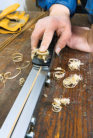 Rod making plane in use cutting a piece of bamboo