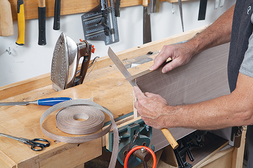 Cutting end off veneer with hand saw