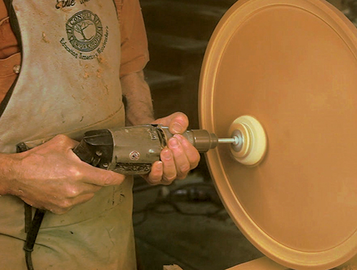 Buffing candlestand tabletop with sanding pad on drill