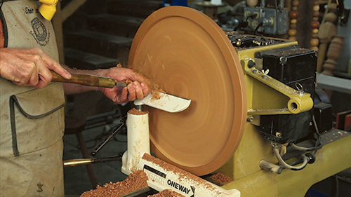 Smoothing candlestand tabletop with boat tailed scraper