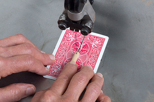 Using playing card to stabilize dowel for slot cut