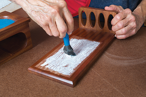 Spreading glue on unfinished area of box base