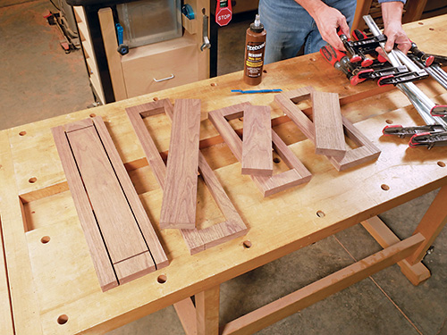 Laying out cabinet rail pieces on workbench