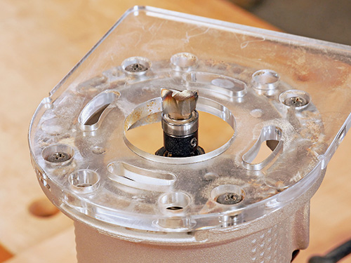 Mortising pattern routing bit installed into a handheld router