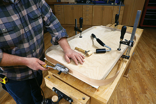Ironing on edge banding onto sides of chevron table