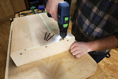 Screwing shelving in place under tabletop