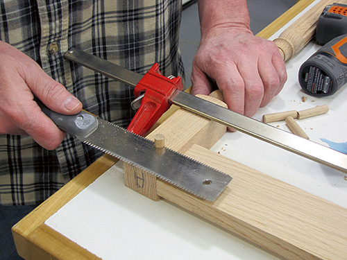 Trimming excess wood off of table leg pinning tenon