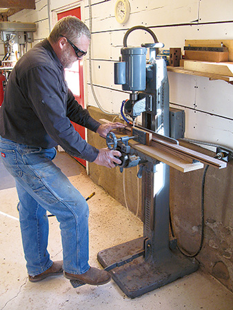 Using a dedicated mortising machine to cut parts for a bookcase.