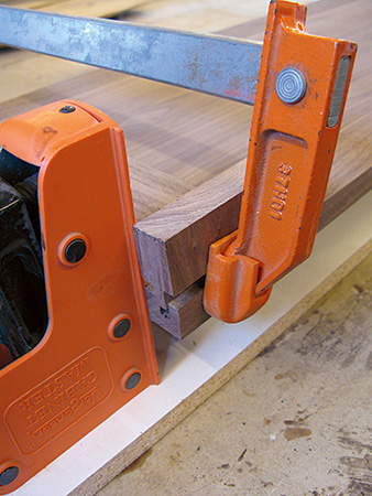 Close up on walnut bookcase frame and panel clamping