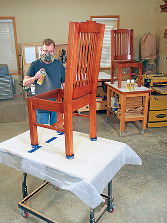 Spraying shellac over stain finish on cloud lift dining chair