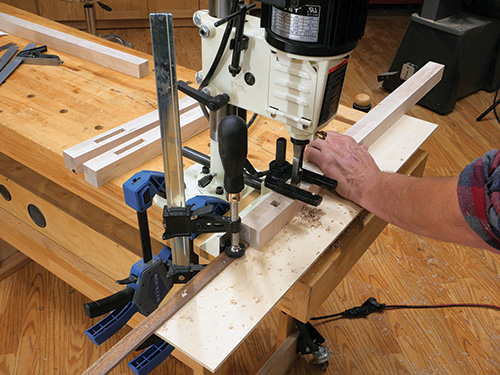 Cutting out mortises in table leg with mortising machine