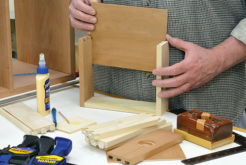 Assemble the two drawers, check for square, and clamp up till dry. In the modern drawer fitting technique, you slide the bottom into a groove cut in the four sides, then attach the final drawer side.