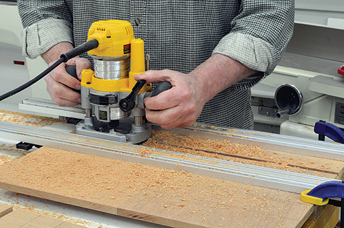 With the drawer module sides clamped edge-to-edge, rout the dadoes for the drawer shelves. The clamps not only hold the workpieces together, but are also placed to act as guides for the router.