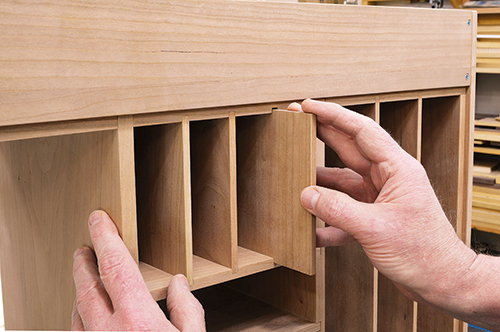 Once carcass assembly is done, give each of the dividers a test fit. Too tight? Ease the fit with a sanding block.