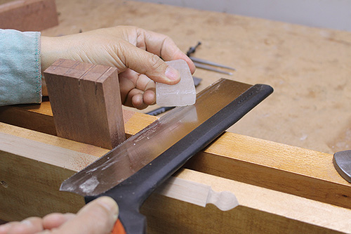 Adjusting friction of hand saw blade with wax