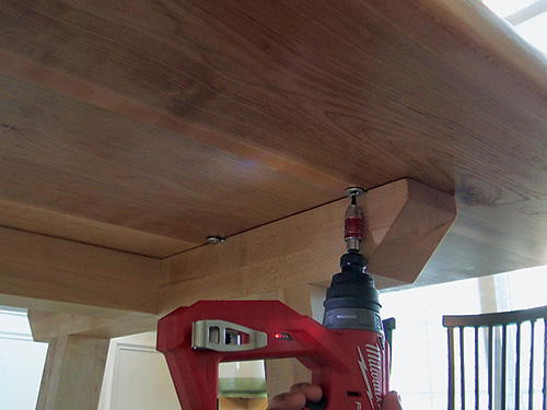 Screwing tabletop in place with desktop fasteners