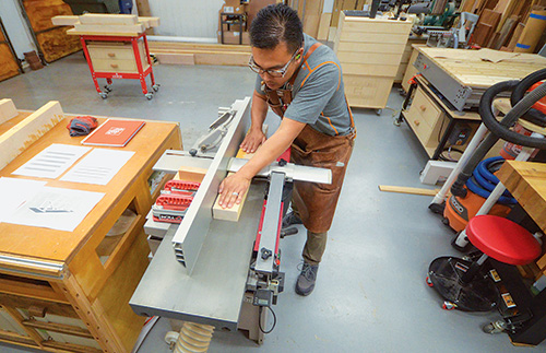 Running dining table lumber through jointer