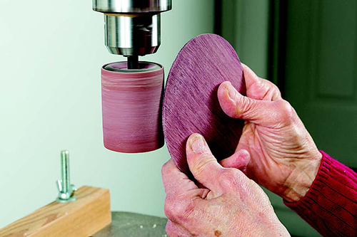 A small pneumatic drum, chucked into a drill press, gives a great deal of control as you round and thin the upper edge of the lid.