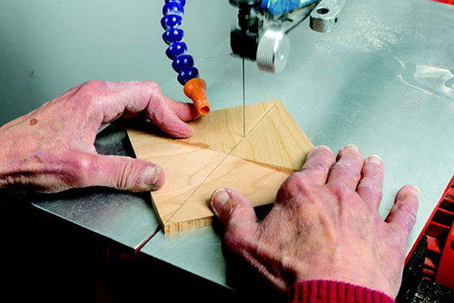 Next, invert one half of each piece and glue it to its mate, using Nexabond, to form a chevron. When the pieces have set, make a second diagonal cut across the uncut corners.