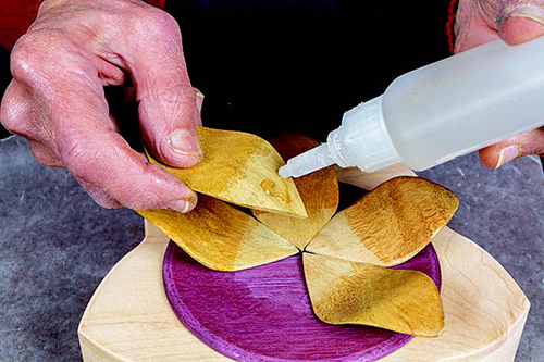 Once the shellac has dried, the petals are attached one at a time with Nexabond.