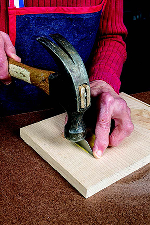 The author cut the yellow veneer into the stamen pieces by tapping a razor blade as shown. Make plenty of extras to allow for breakage.
