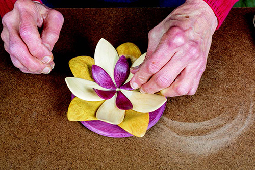 After the purpleheart petals are trimmed back, glue them into place. Work one petal at a time, and hold the glued end down until the petal maintains its position.