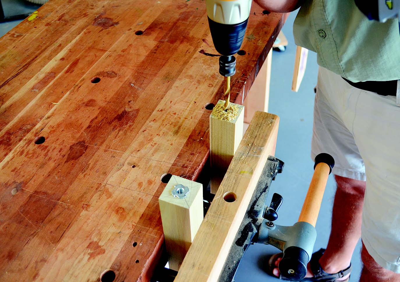 Drilling out holes for installing feet in folding workbench legs