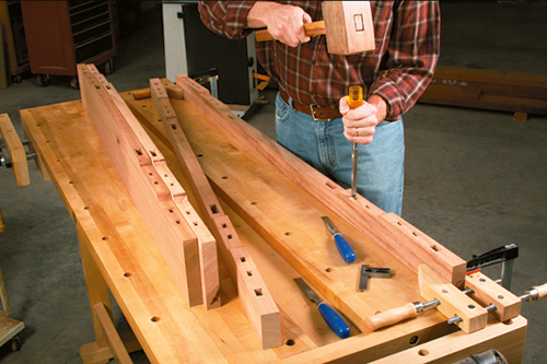Cleaning mortises in bed rail with chisel