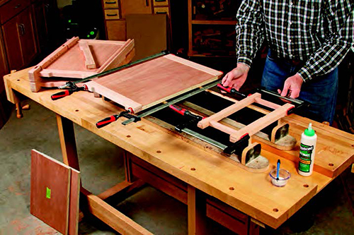 The back panel and rails form a third major subassembly, while the top and middle front rails and full slats make a fourth subassembly. Gluing these parts together now reduces the total number of wet glue joints in the final big carcass glue-up — and that makes the whole assembly process easier.