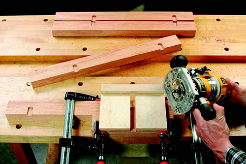 A clamp-on routing jig, with a slot sized to match the fixed shelf and bottom panel plywood thickness, ensures accurately made dadoes in the legs.