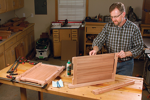 Form two side assemblies by gluing the legs, side rails and panels together. Glue the side panels into their grooves — their veneer/plywood construction makes wood movement a nonissue here.