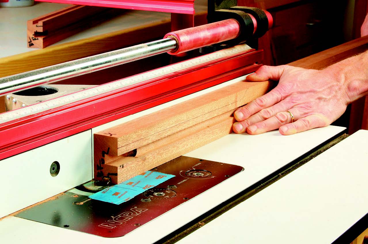 Plow a 1/2"-wide groove down the narrow, inside face of the back legs for the dresser’s back panel. Mark the limits of your router bit with a strip of masking tape so you'll know when to stop these cuts. They terminate 1-3⁄4" up from the leg bottoms.