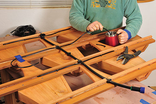 Attaching watering system to deck planter frame