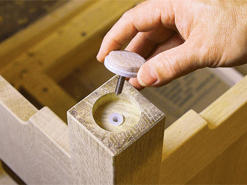 Adding leg leveler to recess in chair leg