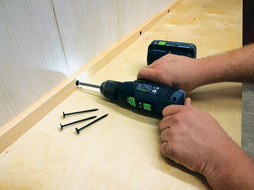 Completing installation of Murphy bed on wall