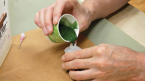 Pouring resin mixture into container for injection