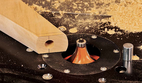 The curved edges of the legs are given a vintage “fingernail” profile by routing them from both sides using a roundover bit in a router table.