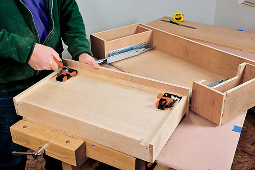 Special plastic clips screwed to the bottom of the maple drawer serve to attach the drawer to full-extension “push-to-open” drawer slides.
