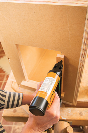 Pin nailing lending library window trim in place