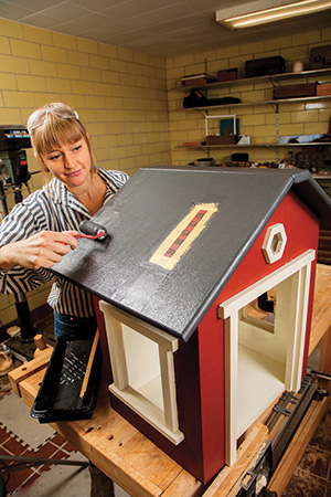 Applying exterior paint to a lending library roof