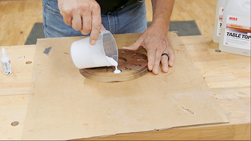 Pouring epoxy into openings on clock face