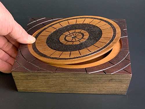 Popping open manhole cover themed box