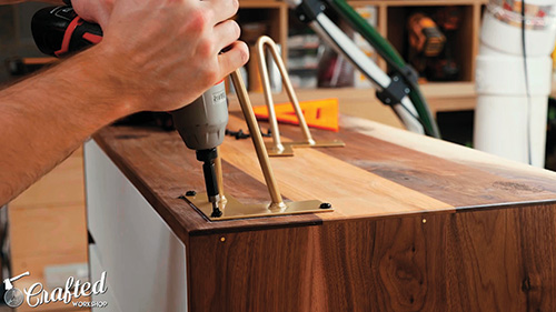 Screwing hairpin legs into place on Mid-century Modern Dresser