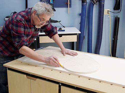 Tracing kidney table shape on plywood panel