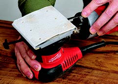 The Milwaukee holds sandpaper solidly, but the dust bag interferes with operation of the rear clamp.