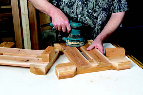 Sanding down surface of picnic table bench side