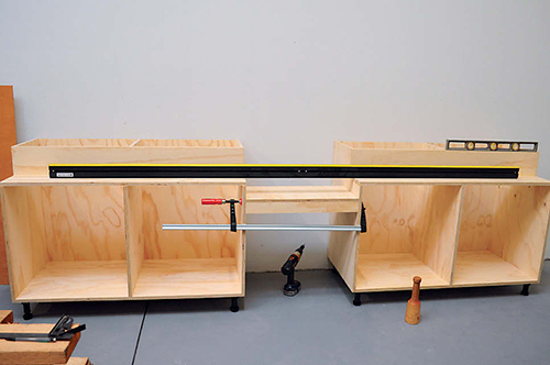 Adjust the leveling legs until the cut shelves are flat along their combined length.