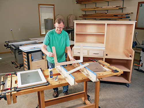 Assembling cabinet door frames along with sheet metal panels