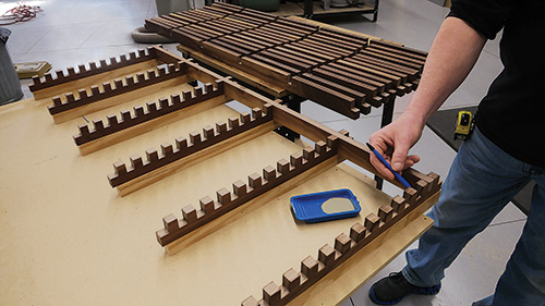 Applying glue with a brush to cross-lap notches for a coffee table